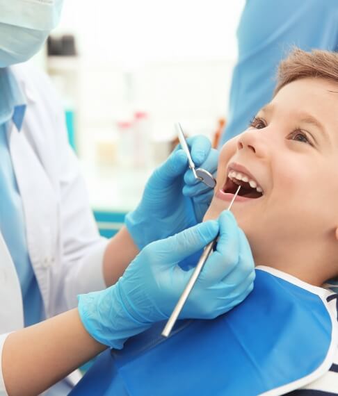 Young patient receiving children's dental checkup and teeth cleaning