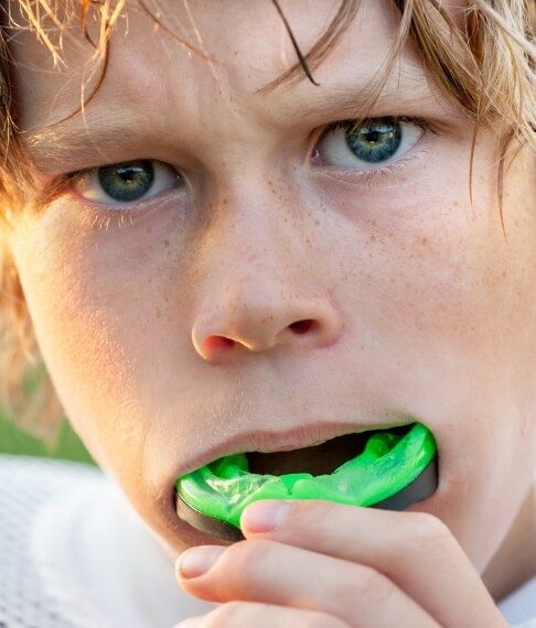 Teen placing an athletic mouthguard