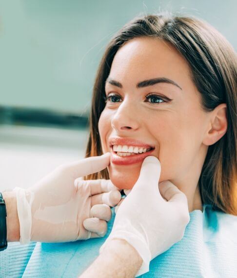 Dentist examining patient's smile after metal free dental restorations