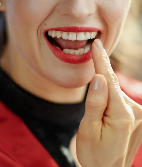 Patient pointing to smile after makeover