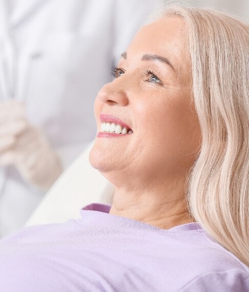 Woman smiling after dental implant tooth replacement