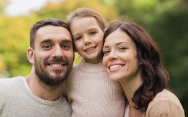 Parents and child smiling after children's dentistry