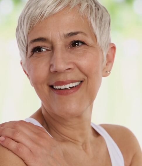 Woman with complete smile after replacing missing teeth