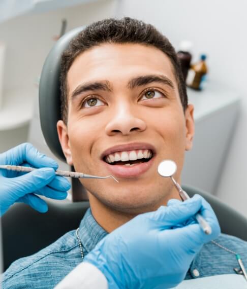 Man receiving dental checkup and teeth cleaning