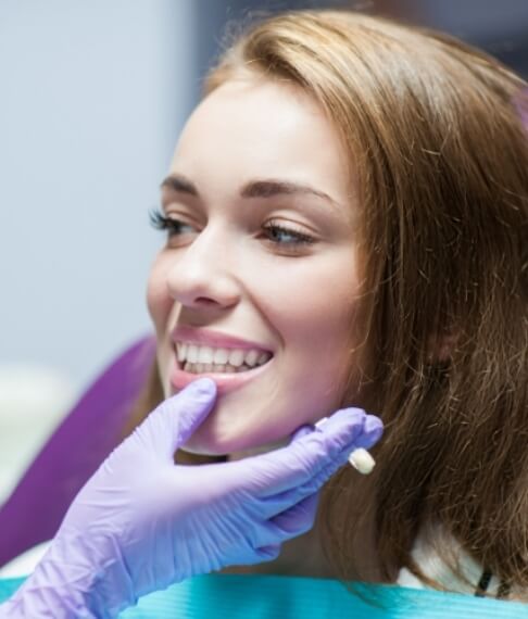 Dentist examining patient's smile after restorative dentistry treatment