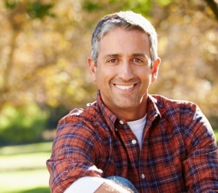 Man with flawless smile after replacing missing teeth