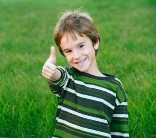 Young dnetal patient giving thumbs up after children's dentistry visit