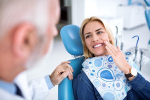 Woman visiting her emergency dentist because of severe tooth pain.