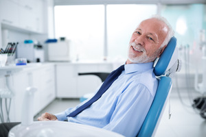 Senior man in dental chair smiling
